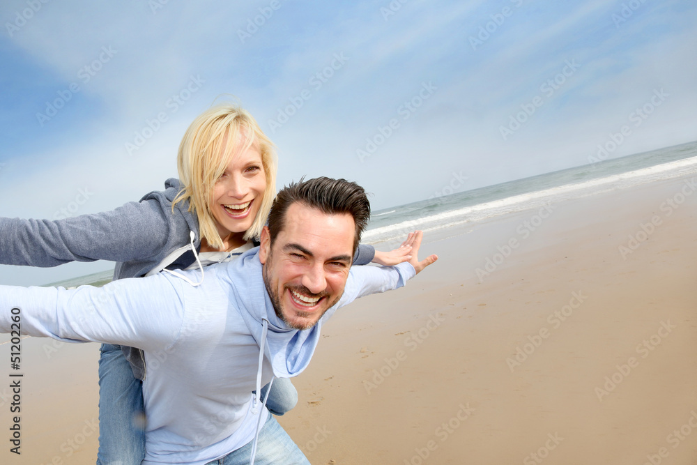 Middle-aged couple having fun on a sandy beach