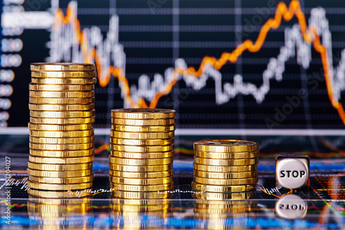 Downtrend financial chart, stacks of golden coins and dices cube
