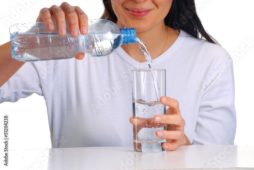 Mujer sirviendo agua potable en un vaso,agua mineral. photo