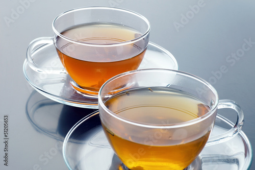 Transparent cup with green and black tea