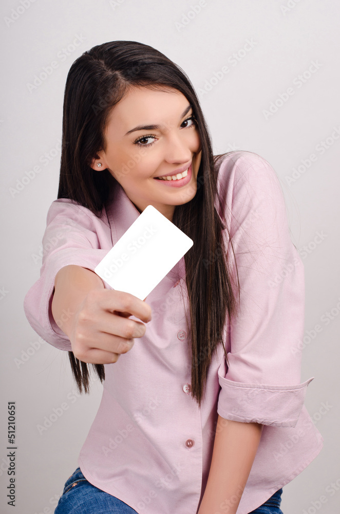 Young woman smiling holding a blank business card. Young woman smiling holding a blank business card.