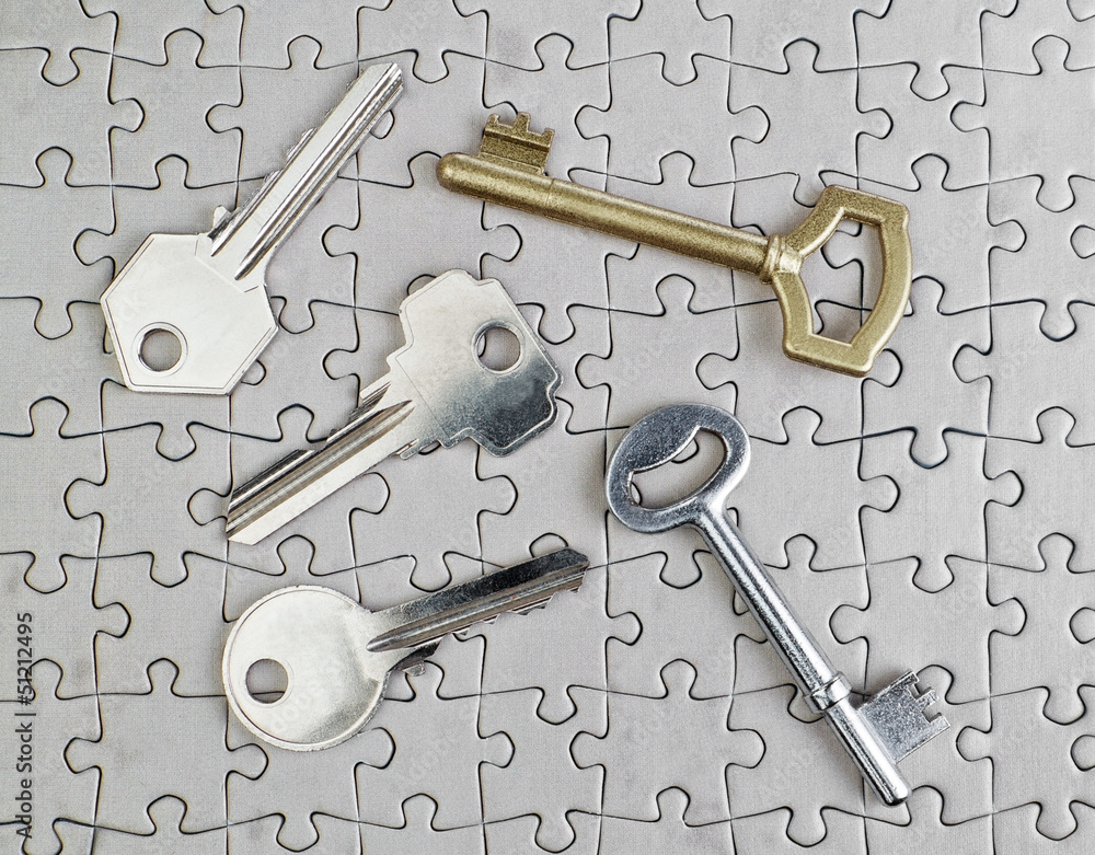 Fototapeta premium Keys of different types of puzzles on a close-up of gold and sil