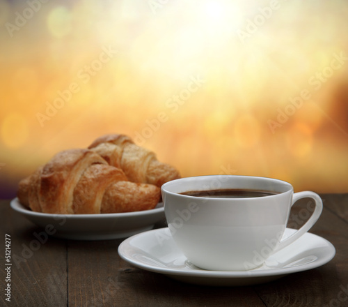 morning breakfast - coffee and croissant in sunrise