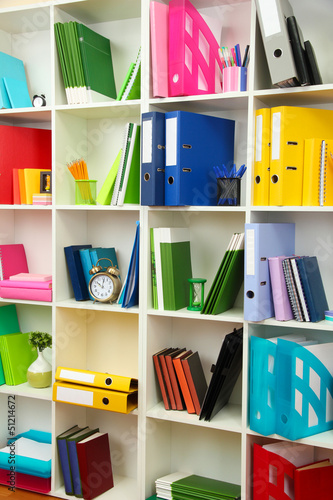 White office shelves with different stationery, close up