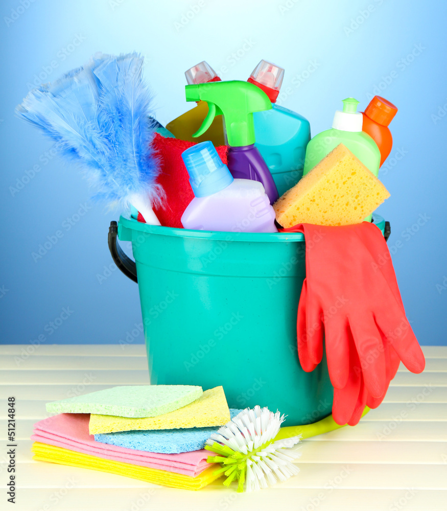 Cleaning items in bucket on color background Cleaning items in bucket on color background