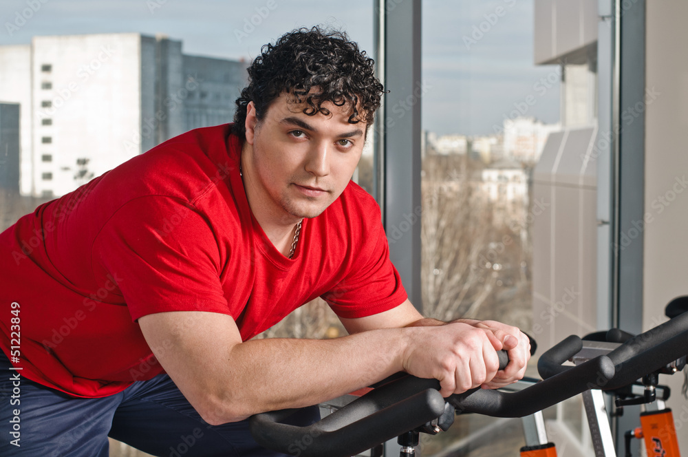 young man on exercise bicycle young man on exercise bicycle