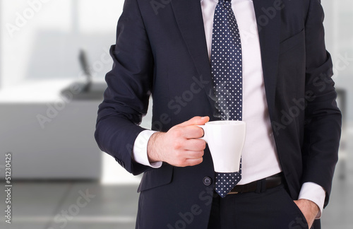 Businessman holding a cup of coffee.