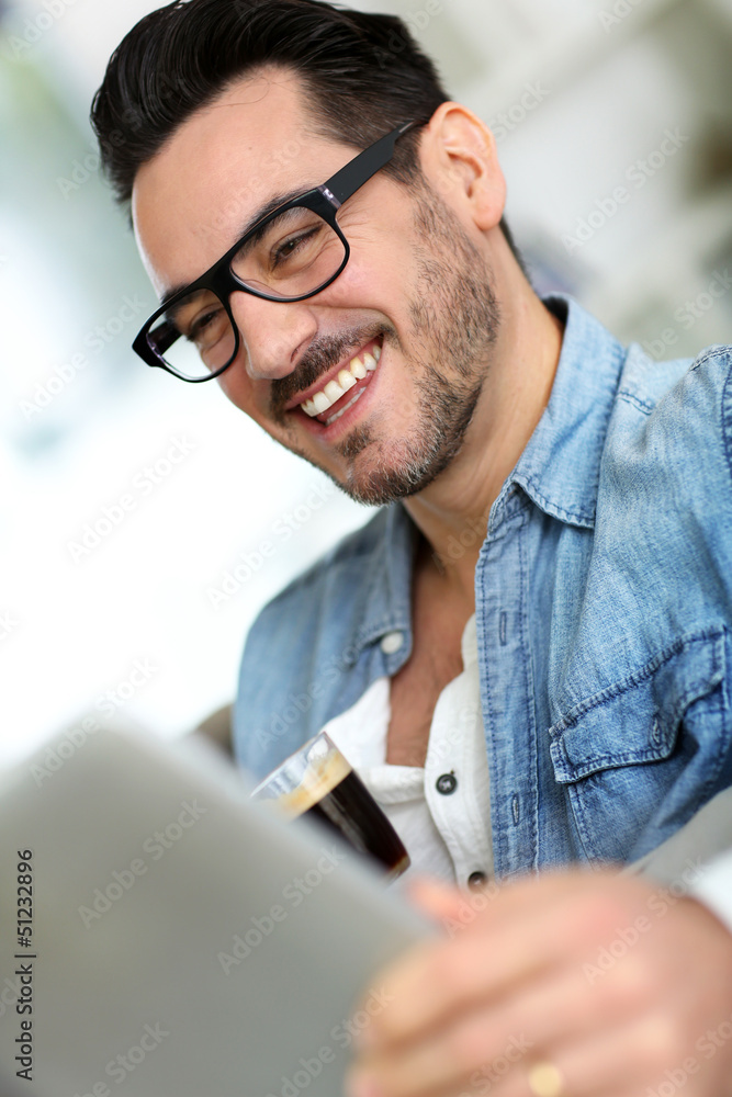 Middle-aged man at home using electronic tablet Middle-aged man at home using electronic tablet