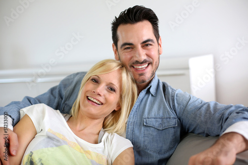Sweet middle-aged couple embracing in sofa