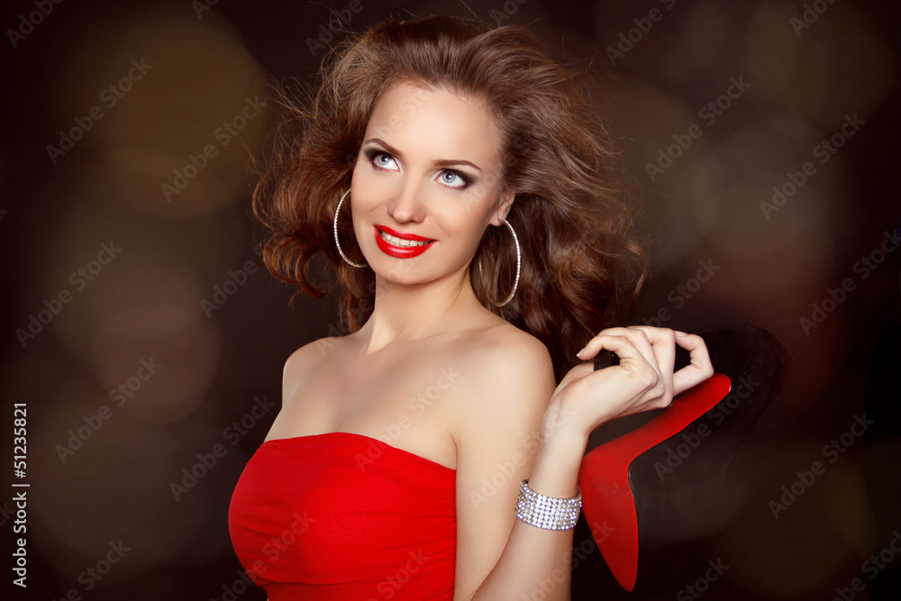 Naklejka premium Woman with beauty long brown hair wearing in red holding shoe o