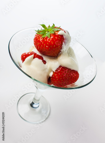 strawberries and cream in a glass on a white background