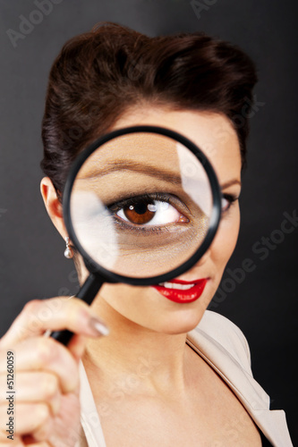 Woman with magnifier on white background