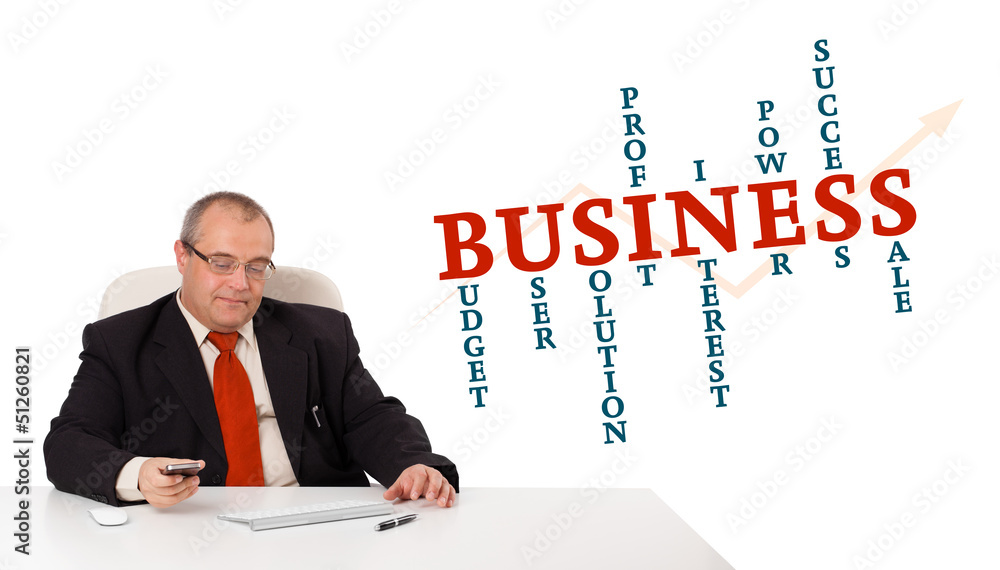 businesman sitting at desk and holding a mobilephone with busine businesman sitting at desk and holding a mobilephone with busine