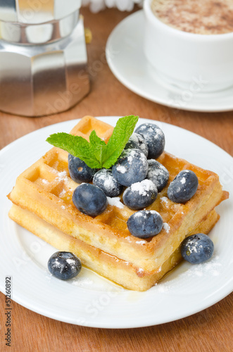 Belgian waffles with blueberries, coffee and fresh fruit