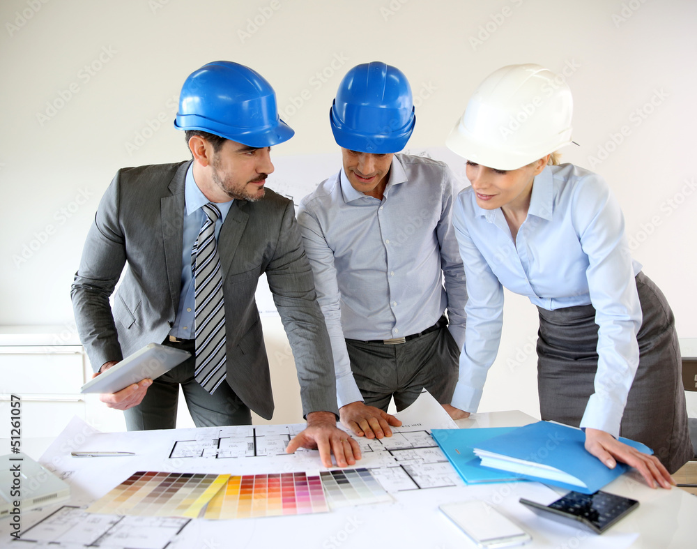Team of architects presenting construction project Team of architects presenting construction project