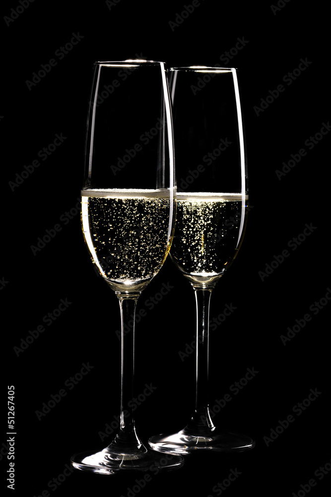 Two glasses of sparkling champagne infront of black Two glasses of sparkling champagne infront of black