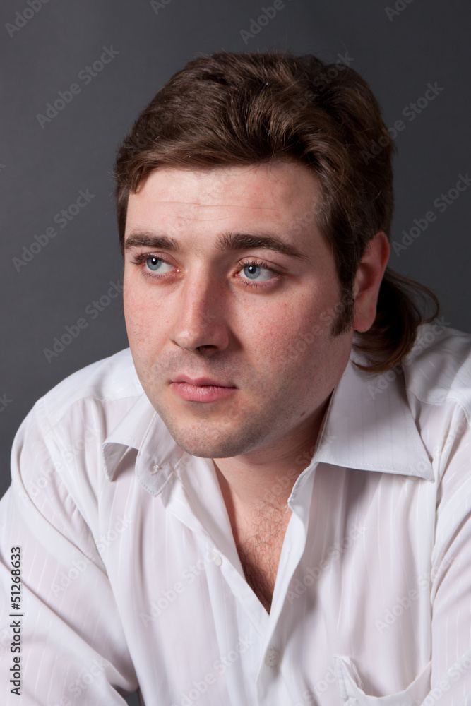 man posing in white shirt on dark background in studio