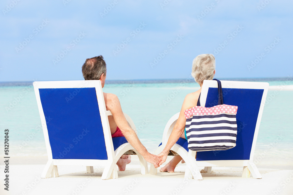Senior Couple On Beach Relaxing In Chairs