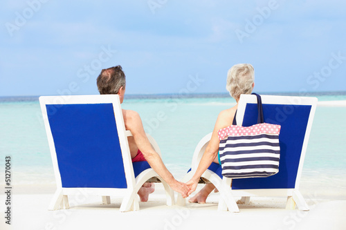 Senior Couple On Beach Relaxing In Chairs