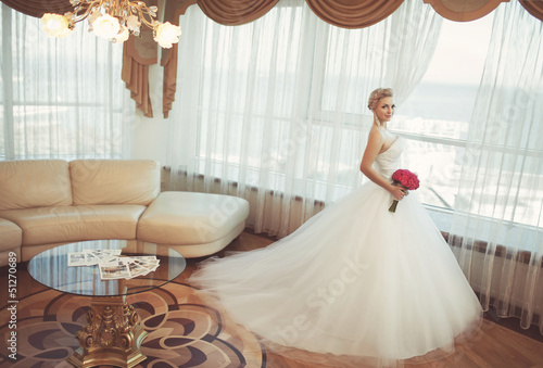 Beautiful bride in wedding dress at home photo