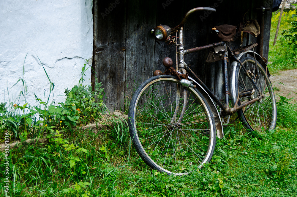 Old vintage bicycle near the house in the village