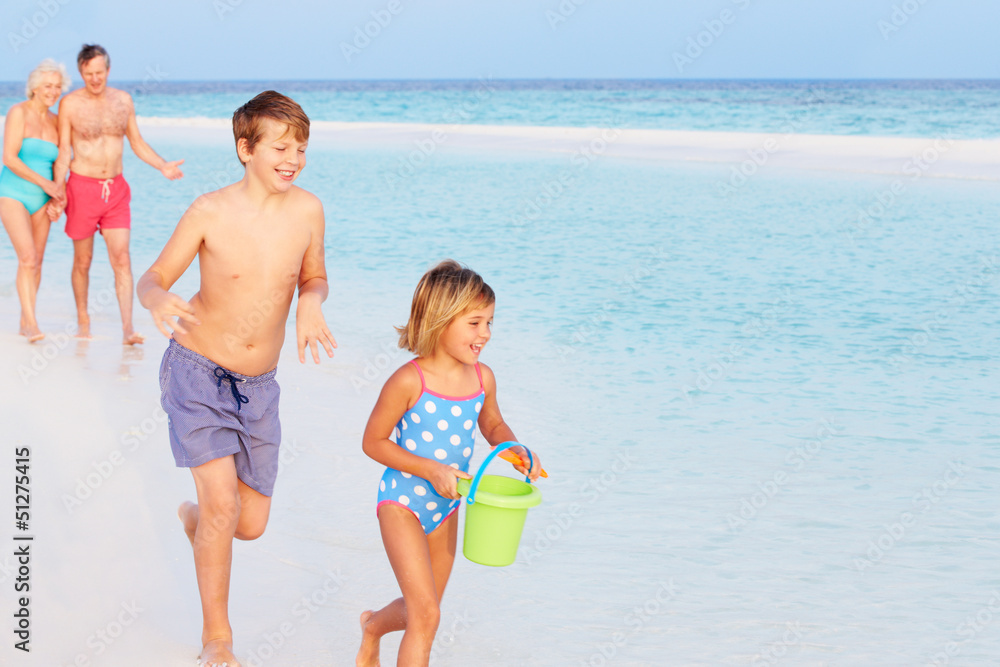Naklejka premium Grandparents And Grandchildren Having Fun On Beach Holiday