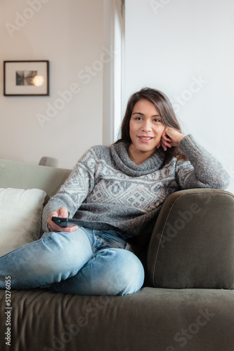Young woman watching tv home in sofa