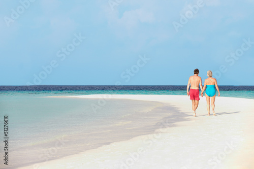 Rear View Of Senior Romantic Couple Walking In Tropical Sea