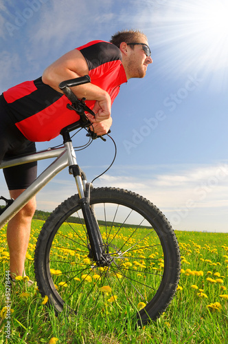 biker with the mountain bike in the dandelion field