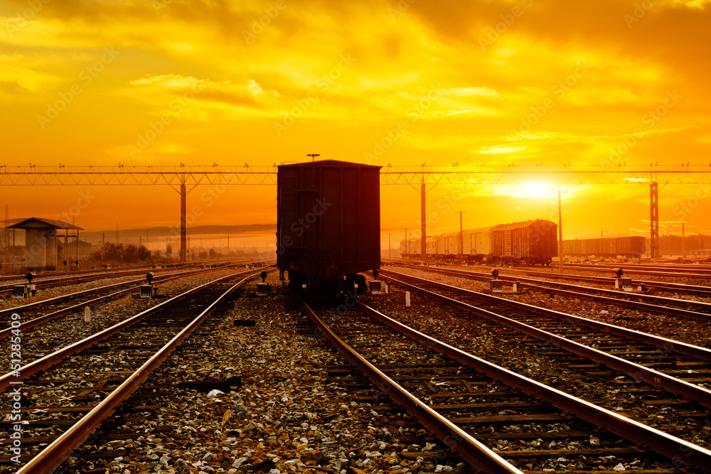 Fototapeta premium reight train passing by on sunset beam