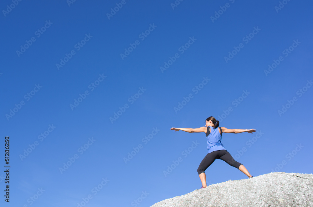 Yoga on a whte rock against a blue sky