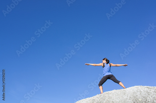 Yoga on a whte rock against a blue sky
