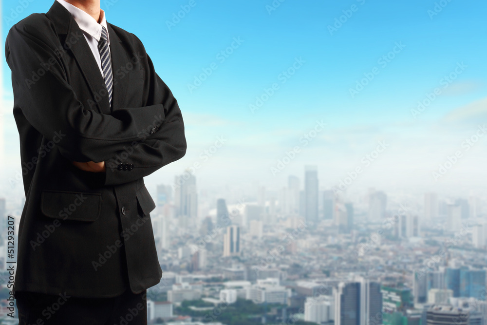 Businessman standing near skyscraper background Businessman standing near skyscraper background
