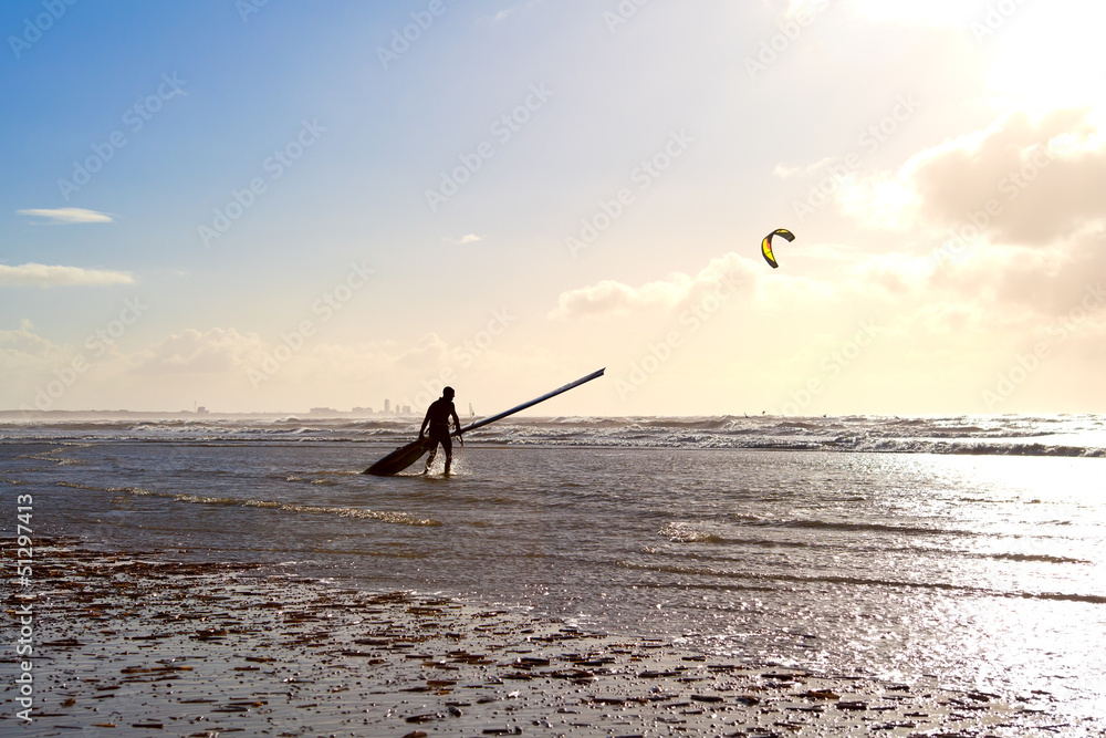 Naklejka premium kitesurfer on beach in waves