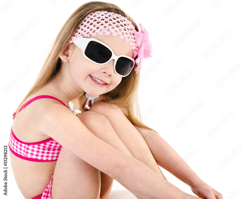 Naklejka premium Cute smiling little girl in swimsuit and sunglasses isolated