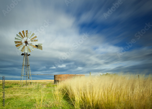long exposure image with windmill and streaky clouds photo