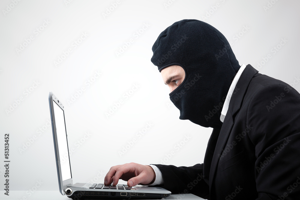 Portrait of a hacker with balaclava against grey background Portrait of a hacker with balaclava against grey background