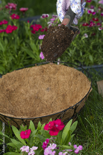 a gardener is about to dump some potting soil