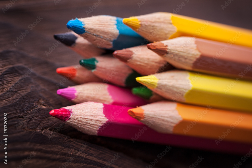 Close up of color pencils isolated on brown background Close up of color pencils isolated on brown background