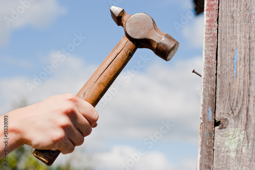 hand with hammer on sky  background photo