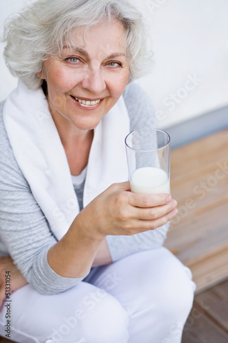 sportliche Seniorin mit einem Glas Milch