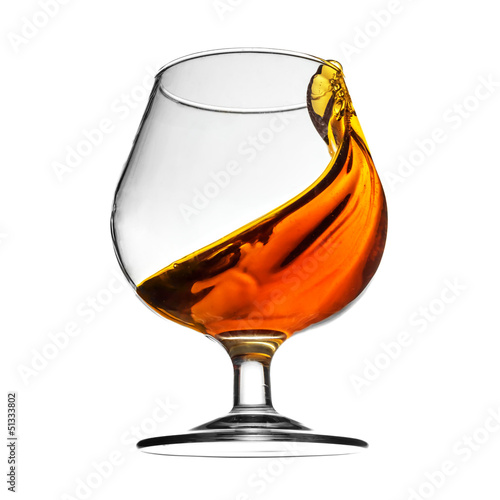 Splash of cognac in glass on white background