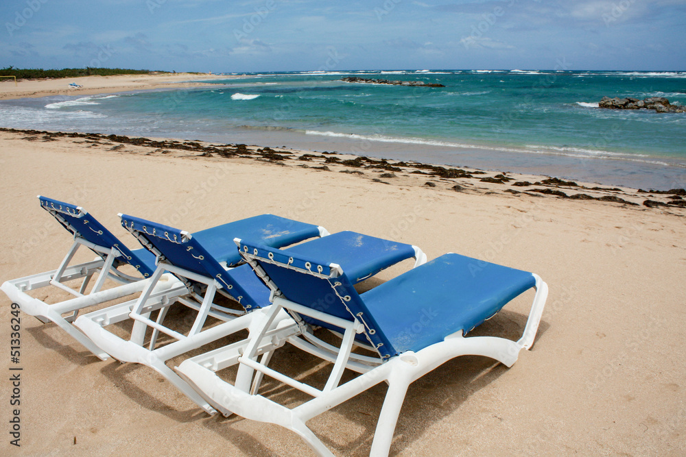 calm beach with deckchairs under the blue sky calm beach with deckchairs under the blue sky