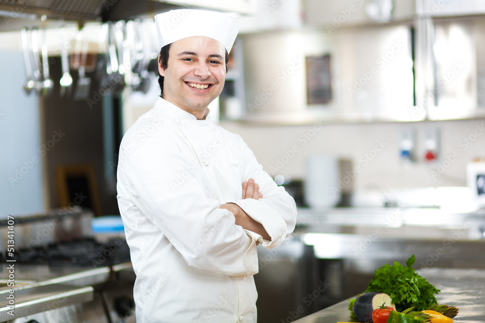 Chef with arms crossed in restaurant kitchen
