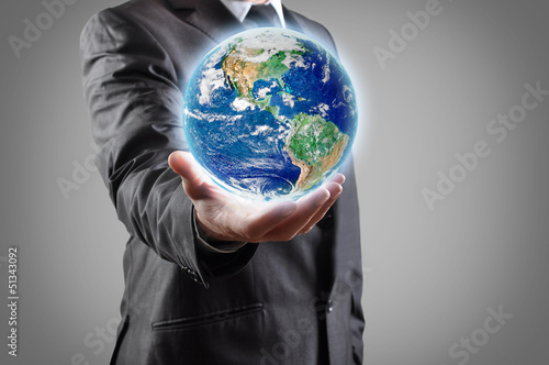 Businessman holds earth in a hand