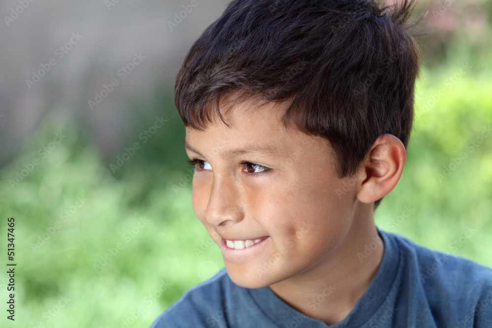 Smiling young boy outside with copy space to left