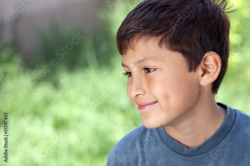 Smiling young boy outside with copy space to left
