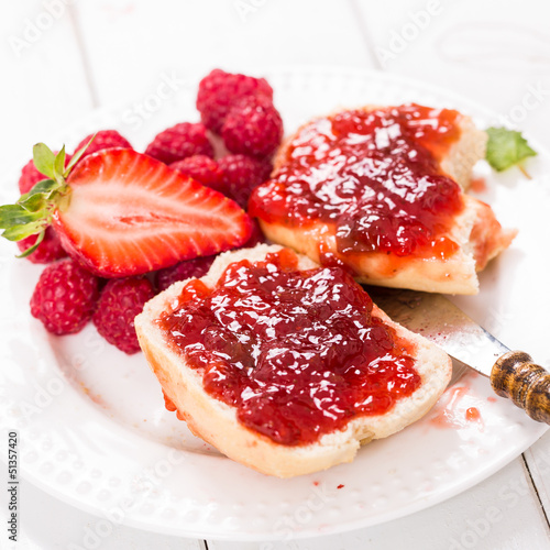 Erdbeer-Himbeermarmelade auf einem Brötchen