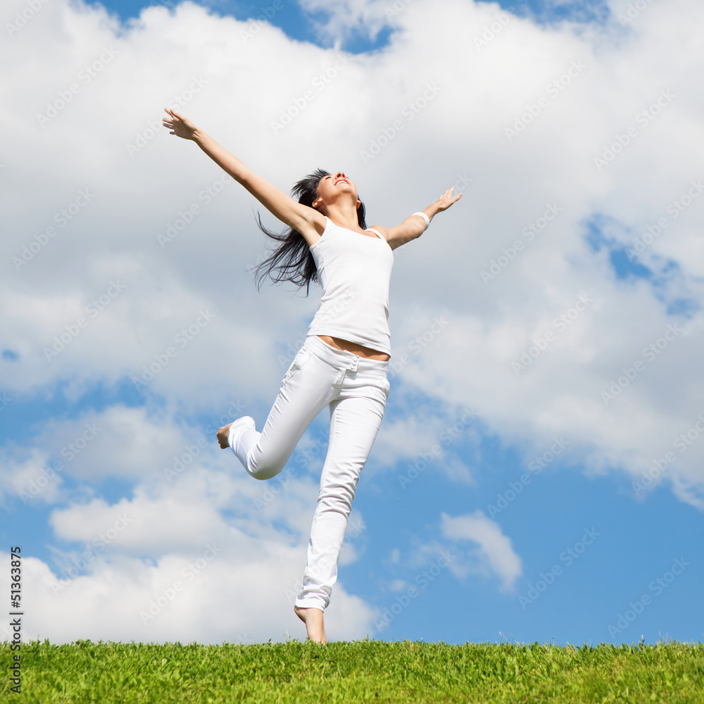 pretty young woman jumping on green grass