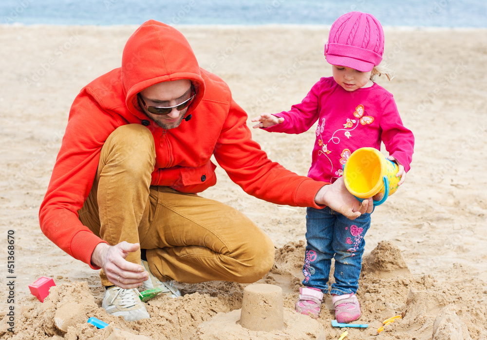 Father and his daughter playing on the beach Father and his daughter playing on the beach